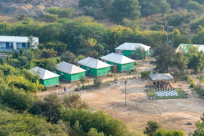 Green Jungle Tents set beneath the rocky hills at Farm Aravalia