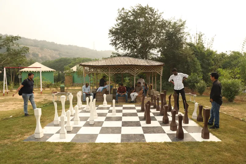 Guests playing oversized outdoor chess on the Farm Aravalia lawns
