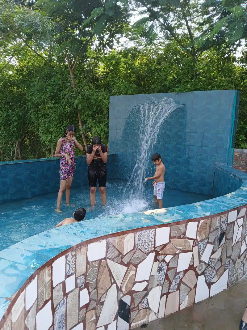 Children enjoying water play in the small pool at Farm Aravalia