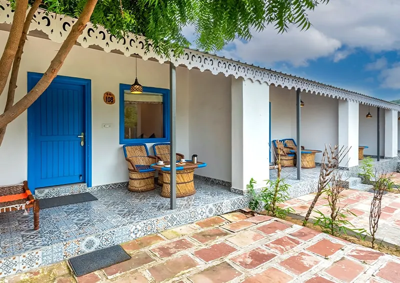 Blue doors and shaded seating outside the Hill View Rooms